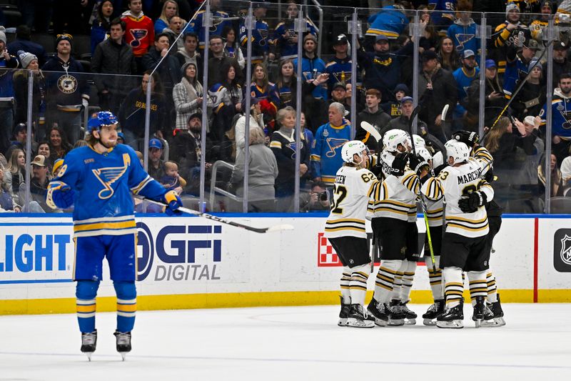 Jan 13, 2024; St. Louis, Missouri, USA;  Boston Bruins defenseman Charlie McAvoy (73) is congratulated on his overtime game winning goal by teammates as St. Louis Blues center Robert Thomas (18) reacts in overtime at Enterprise Center. Mandatory Credit: Jeff Curry-USA TODAY Sports