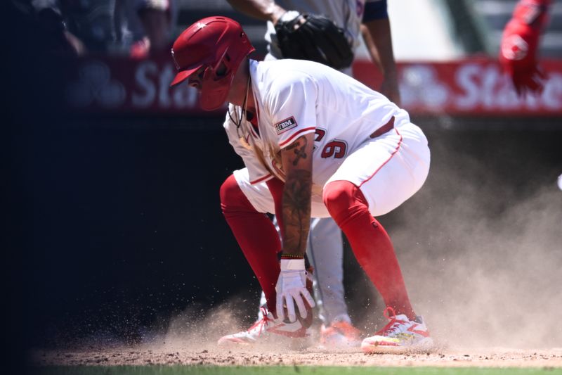 Aug 4, 2024; Anaheim, California, USA; Los Angeles Angels shortstop Zach Neto (9) slides into home plate to score against the New York Mets during the third inning at Angel Stadium. Mandatory Credit: Jonathan Hui-USA TODAY Sports