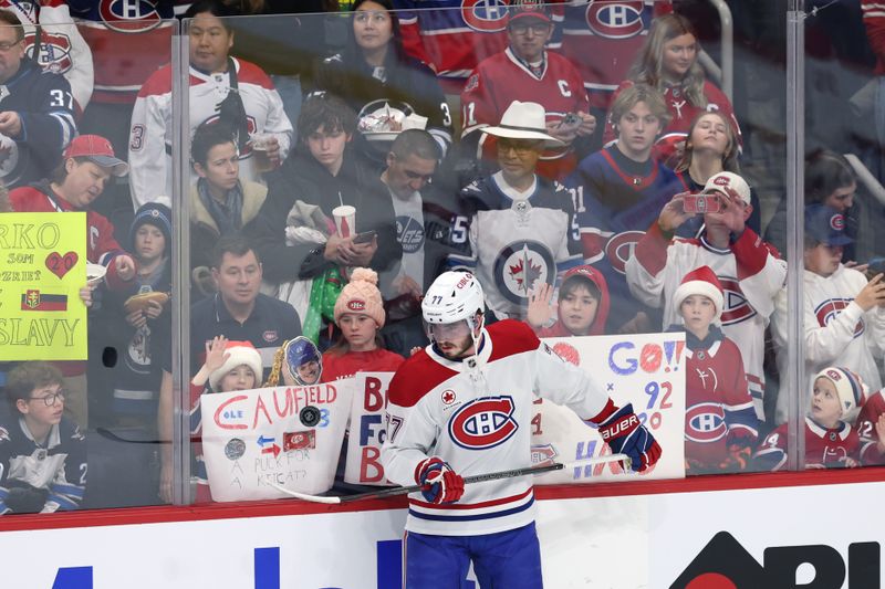 Dec 14, 2024; Winnipeg, Manitoba, CAN; Montreal Canadiens center Kirby Dach (77) puck juggles in front of fans before a game against the Winnipeg Jets at Canada Life Centre. Mandatory Credit: James Carey Lauder-Imagn Images