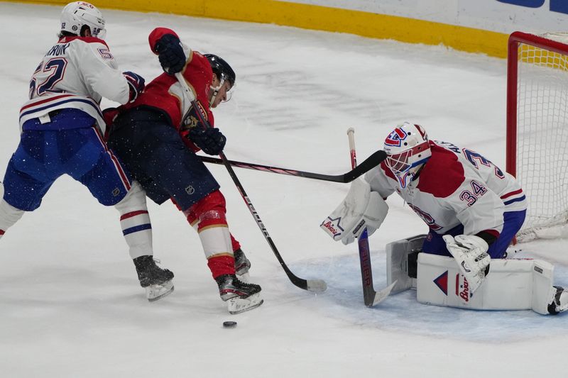 Dec 30, 2023; Sunrise, Florida, USA;  Florida Panthers center Eetu Luostarinen (27) gets driven off the puck by Montreal Canadiens defenseman Justin Barron (52) as goaltender Jake Allen (34) gathers the puck during the second period at Amerant Bank Arena. Mandatory Credit: Jim Rassol-USA TODAY Sports