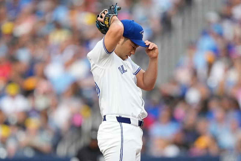 Jul 26, 2024; Toronto, Ontario, CAN; Toronto Blue Jays starting pitcher Yusei Kikuchi (16) adjusts his hat during first inning against the Texas Rangers at Rogers Centre. Mandatory Credit: John E. Sokolowski-USA TODAY Sports