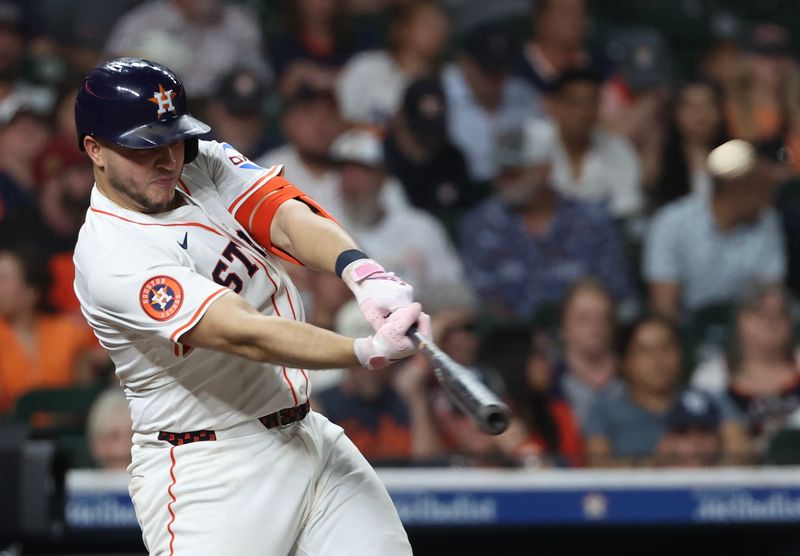 May 29, 2025; Houston, Texas, USA;  Houston Astros catcher Yainer Diaz (21) hits a home run against the Tampa Bay Rays in the fifth inning at Daikin Park. Mandatory Credit: Thomas Shea-Imagn Images