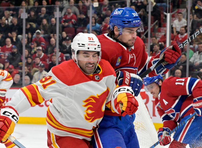 Nov 14, 2023; Montreal, Quebec, CAN; Calgary Flames forward Nazem Kadri (91) collides with Montreal Canadiens forward Sean Monahan (91) during the third period at the Bell Centre. Mandatory Credit: Eric Bolte-USA TODAY Sports