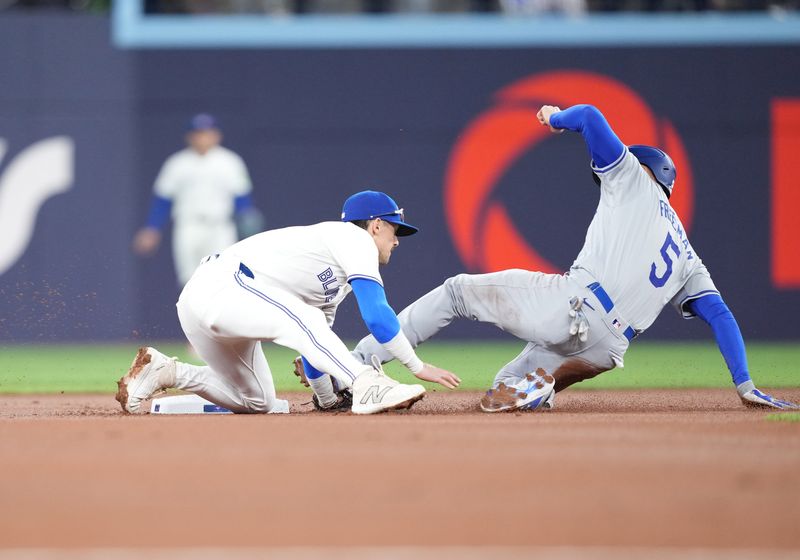 Apr 26, 2024; Toronto, Ontario, CAN; Los Angeles Dodgers first base Freddie Freeman (5) is tagged out by Toronto Blue Jays second base Cavan Biggio (8) during the first inning at Rogers Centre. Mandatory Credit: Nick Turchiaro-USA TODAY Sports