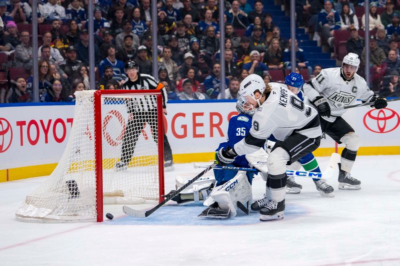 Jan 16, 2025; Vancouver, British Columbia, CAN; Vancouver Canucks defenseman Derek Forbort (27) and Los Angeles Kings forward Anze Kopitar (11) watch as forward Adrian Kempe (9) scores on goalie Thatcher Demko (35) in the first period at Rogers Arena. Mandatory Credit: Bob Frid-Imagn Images