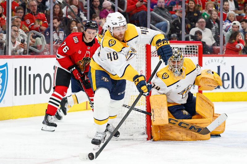 Mar 22, 2026; Chicago, Illinois, USA; Nashville Predators defenseman Nick Perbix (48) passes the puck away from Chicago Blackhawks left wing Nick Lardis (76) during the first period at United Center. Mandatory Credit: Kamil Krzaczynski-Imagn Images