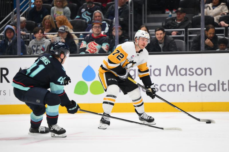 Jan 25, 2025; Seattle, Washington, USA; Pittsburgh Penguins left wing Anthony Beauvillier (72) looks to pass the puck while defended by Seattle Kraken defenseman Ryker Evans (41) during the second period at Climate Pledge Arena. Mandatory Credit: Steven Bisig-Imagn Images