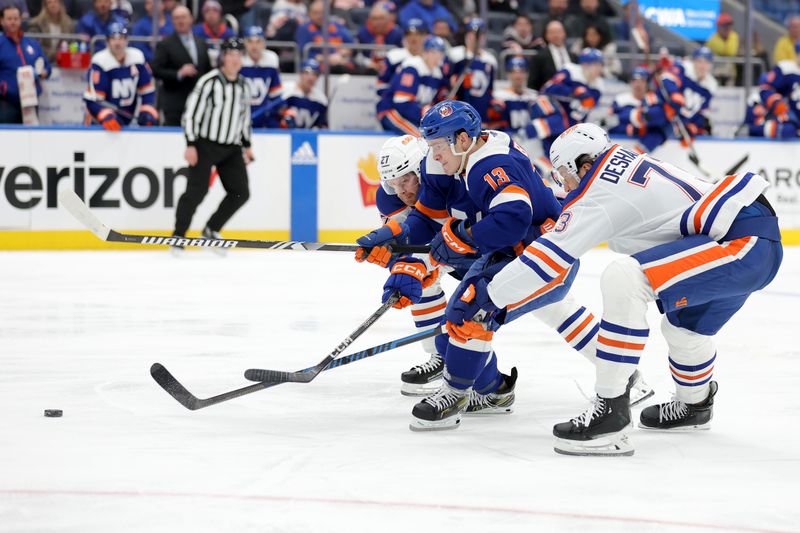 Dec 19, 2023; Elmont, New York, USA; New York Islanders center Mathew Barzal (13) fights for the puck against Edmonton Oilers defenseman Brett Kulak (27) and defenseman Vincent Desharnais (73) during the second period at UBS Arena. Mandatory Credit: Brad Penner-USA TODAY Sports