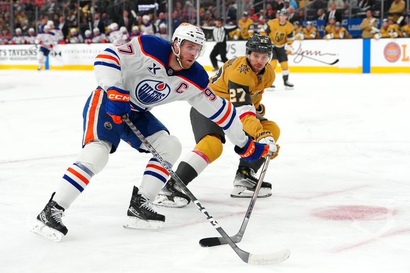 Dec 3, 2024; Las Vegas, Nevada, USA; Edmonton Oilers center Connor McDavid (97) protects the puck from Vegas Golden Knights defenseman Shea Theodore (27) during the first period at T-Mobile Arena. Mandatory Credit: Stephen R. Sylvanie-Imagn Images