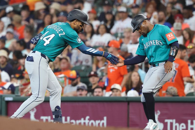 May 25, 2025; Houston, Texas, USA; Seattle Mariners center fielder Julio Rodriguez (44) celebrates with first base coach Eric Young Jr. (53) after hitting a single during the third inning against the Houston Astros at Daikin Park. Mandatory Credit: Troy Taormina-Imagn Images