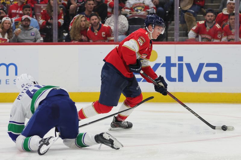 Oct 17, 2024; Sunrise, Florida, USA; Florida Panthers center Anton Lundell (15) moves the puck past Vancouver Canucks defenseman Noah Juulsen (47) during the third period at Amerant Bank Arena. Mandatory Credit: Sam Navarro-Imagn Images