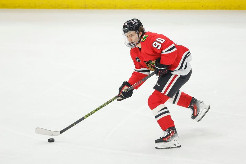 Feb 25, 2024; Chicago, Illinois, USA; Chicago Blackhawks center Connor Bedard (98) controls the puck against the Detroit Red Wings during the first period at United Center. Mandatory Credit: Kamil Krzaczynski-USA TODAY Sports