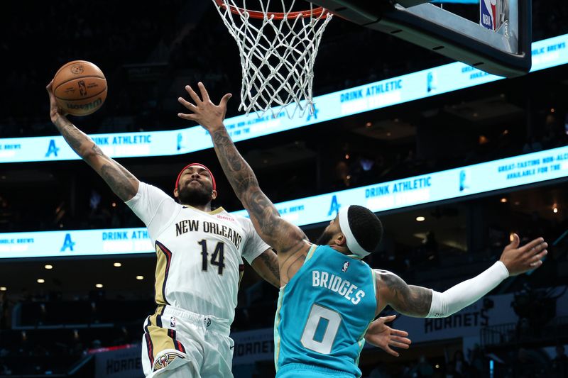 CHARLOTTE, NORTH CAROLINA - DECEMBER 15:  Brandon Ingram #14 of the New Orleans Pelicans dunks the ball while being defended by Miles Bridges #0 of the Charlotte Hornets during the first period of the game at Spectrum Center on December 15, 2023 in Charlotte, North Carolina. NOTE TO USER: User expressly acknowledges and agrees that, by downloading and or using this photograph, User is consenting to the terms and conditions of the Getty Images License Agreement. (Photo by Jared C. Tilton/Getty Images)