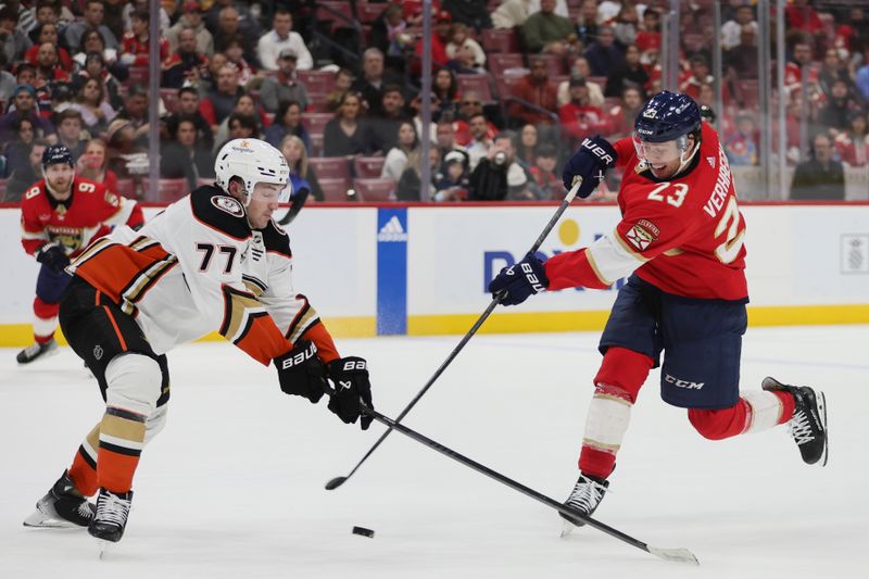 Jan 15, 2024; Sunrise, Florida, USA; Florida Panthers center Carter Verhaeghe (23) shoots the puck as Anaheim Ducks right wing Frank Vatrano (77) defends during overtime at Amerant Bank Arena. Mandatory Credit: Sam Navarro-USA TODAY Sports