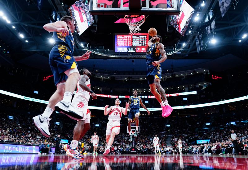 TORONTO, ON - NOVEMBER 18: Obi Toppin #1 of the Indiana Pacers goes up for a slam dunk with teammate T.J. McConnell #9 against the Toronto Raptors during the second half of their basketball game at the Scotiabank Arena on November 18, 2024 in Toronto, Ontario, Canada. NOTE TO USER: User expressly acknowledges and agrees that, by downloading and/or using this Photograph, user is consenting to the terms and conditions of the Getty Images License Agreement. (Photo by Mark Blinch/Getty Images)