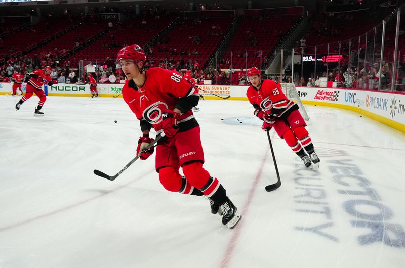 Mar 21, 2024; Raleigh, North Carolina, USA; Carolina Hurricanes center Martin Necas (88) and left wing Jake Guentzel (59) skate during the warmups before the game against the Philadelphia Flyers at PNC Arena. Mandatory Credit: James Guillory-USA TODAY Sports