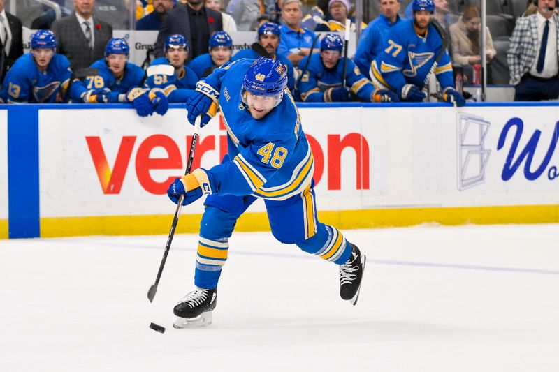 Nov 9, 2024; St. Louis, Missouri, USA;  St. Louis Blues defenseman Scott Perunovich (48) shoots against the Washington Capitals during the second period at Enterprise Center. Mandatory Credit: Jeff Curry-Imagn Images