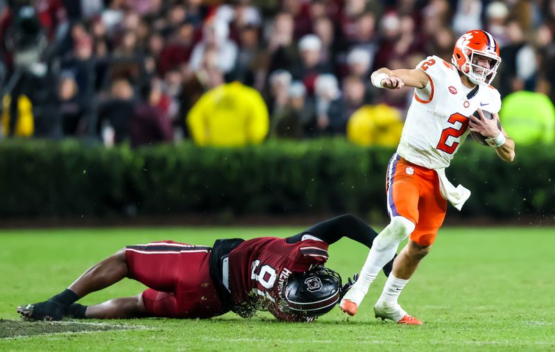 Nov 25, 2023; Columbia, South Carolina, USA; Clemson Tigers quarterback Cade Klubnik (2) pulls away from South Carolina Gamecocks defensive back Peyton Williams (31) in the second half at Williams-Brice Stadium. Mandatory Credit: Jeff Blake-USA TODAY Sports