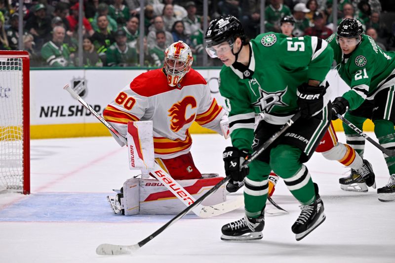 Mar 6, 2025; Dallas, Texas, USA; Dallas Stars center Wyatt Johnston (53) and Calgary Flames goaltender Dan Vladar (80) look for the puck in the Calgary zone during the second period at the American Airlines Center. Mandatory Credit: Jerome Miron-Imagn Images