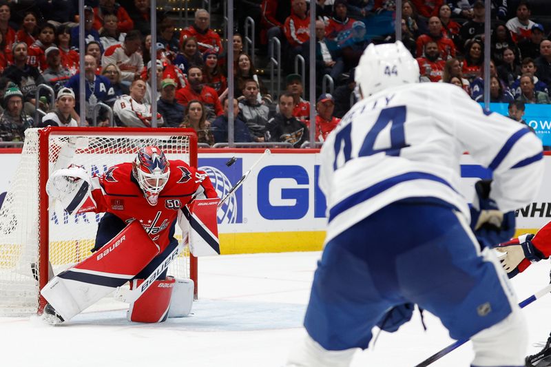 Nov 13, 2024; Washington, District of Columbia, USA; Washington Capitals goaltender Logan Thompson (48) makes a save on Toronto Maple Leafs defenseman Morgan Rielly (44) in the second period at Capital One Arena. Mandatory Credit: Geoff Burke-Imagn Images