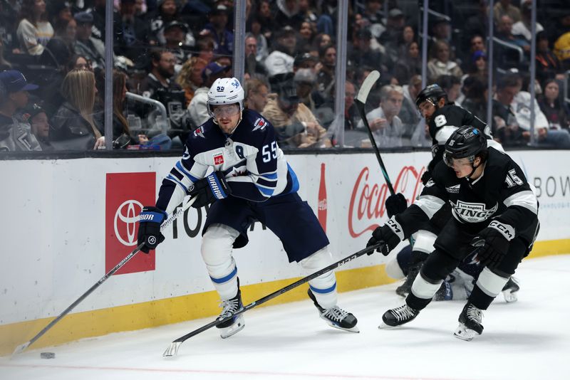 Nov 4, 2025; Los Angeles, California, USA;  Winnipeg Jets center Mark Scheifele (55) controls the puck against Los Angeles Kings center Alex Turcotte (15) during the third period at Crypto.com Arena. Mandatory Credit: Kiyoshi Mio-Imagn Images