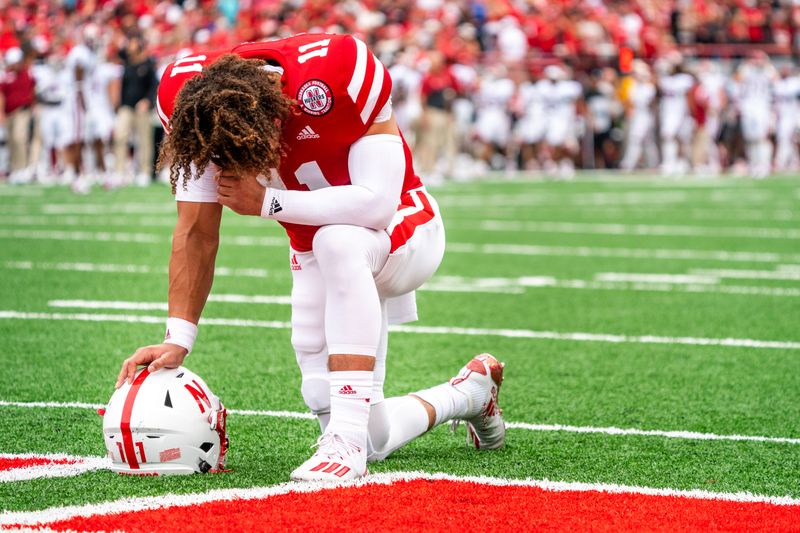 Sep 17, 2022; Lincoln, Nebraska, USA; Nebraska Cornhuskers quarterback Casey Thompson (11) kneels with his head down before the game against the Oklahoma Sooners at Memorial Stadium. Mandatory Credit: Dylan Widger-USA TODAY Sports