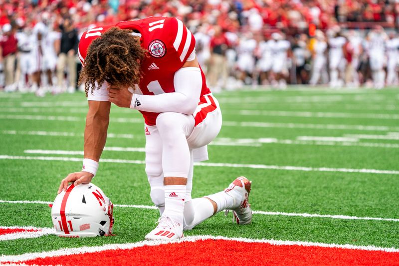 Sep 17, 2022; Lincoln, Nebraska, USA; Nebraska Cornhuskers quarterback Casey Thompson (11) kneels with his head down before the game against the Oklahoma Sooners at Memorial Stadium. Mandatory Credit: Dylan Widger-USA TODAY Sports