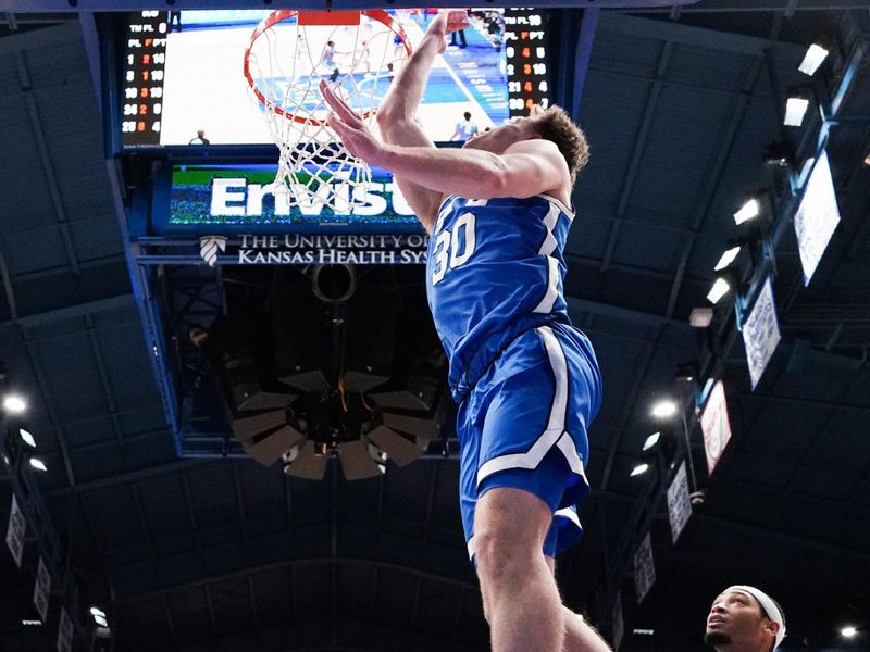 Feb 27, 2024; Lawrence, Kansas, USA; Brigham Young Cougars guard Dallin Hall (30) shoots as Kansas Jayhawks guard Dajuan Harris Jr. (3) looks on during the second half at Allen Fieldhouse. Mandatory Credit: Denny Medley-USA TODAY Sports