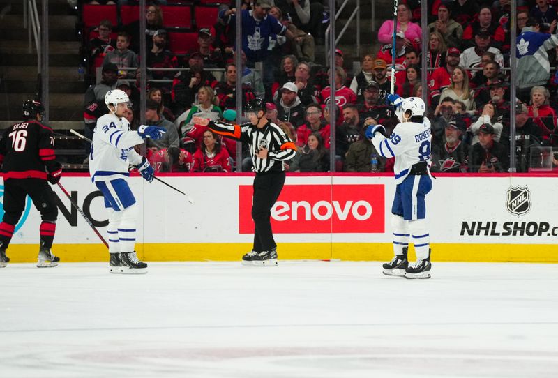 Mar 24, 2024; Raleigh, North Carolina, USA;  Toronto Maple Leafs left wing Nicholas Robertson (89) celebrates his goal with center Auston Matthews (34) against the Carolina Hurricanes during the third period at PNC Arena. Mandatory Credit: James Guillory-USA TODAY Sports