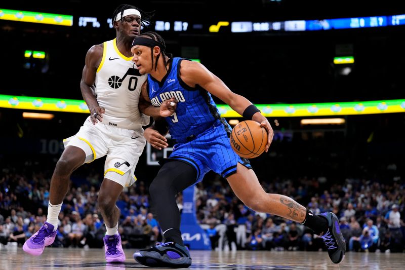 ORLANDO, FLORIDA - FEBRUARY 29: Paolo Banchero #5 of the Orlando Magic dribbles the ball against Taylor Hendricks #0 of the Utah Jazz during the first quarterat Kia Center on February 29, 2024 in Orlando, Florida. NOTE TO USER: User expressly acknowledges and agrees that, by downloading and or using this photograph, user is consenting to the terms and conditions of the Getty Images License Agreement. (Photo by Rich Storry/Getty Images)