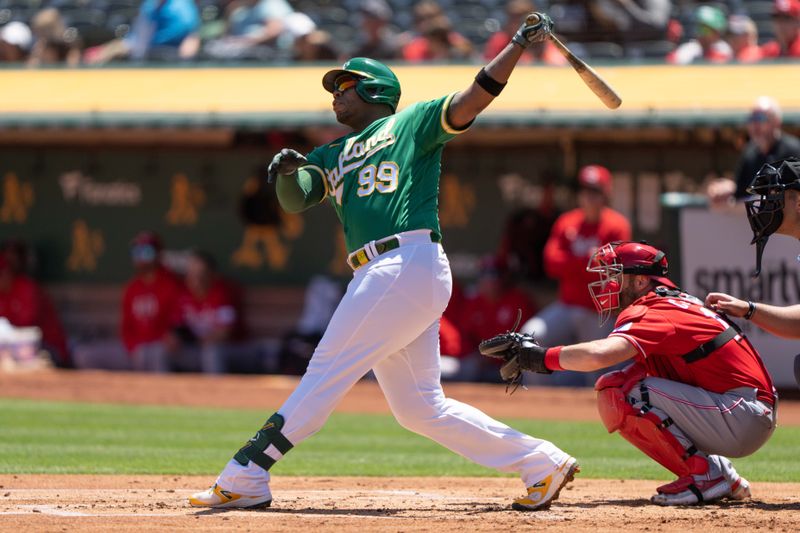 Apr 30, 2023; Oakland, California, USA;  Oakland Athletics first baseman Jesus Aguilar (99) hits a two run home run during the first inning against the Cincinnati Reds at RingCentral Coliseum. Mandatory Credit: Stan Szeto-USA TODAY Sports