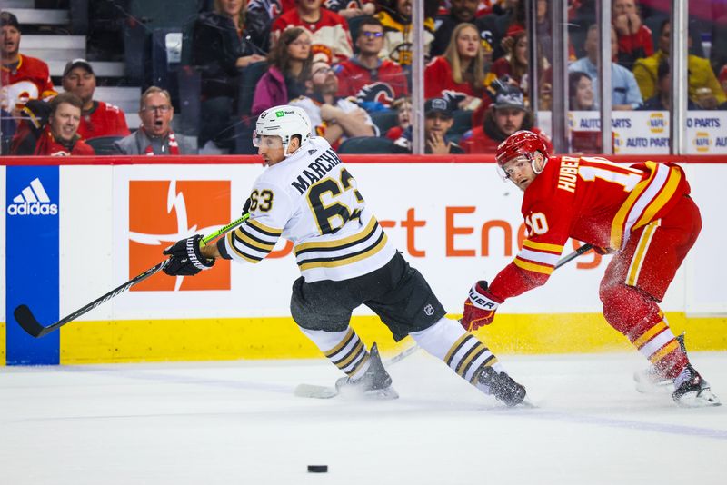 Feb 22, 2024; Calgary, Alberta, CAN; Boston Bruins left wing Brad Marchand (63) and Calgary Flames center Jonathan Huberdeau (10) battles for the puck during the overtime period at Scotiabank Saddledome. Mandatory Credit: Sergei Belski-USA TODAY Sports