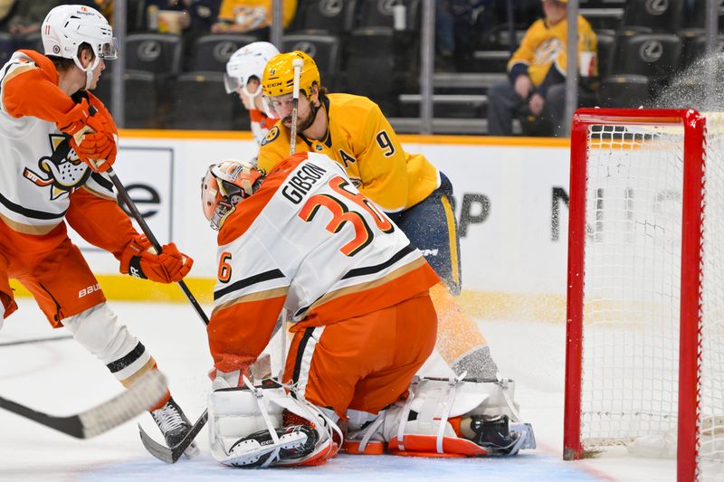 Mar 20, 2025; Nashville, Tennessee, USA;  Anaheim Ducks goaltender John Gibson (36) blocks the shot of Nashville Predators left wing Filip Forsberg (9) during the first period at Bridgestone Arena. Mandatory Credit: Steve Roberts-Imagn Images