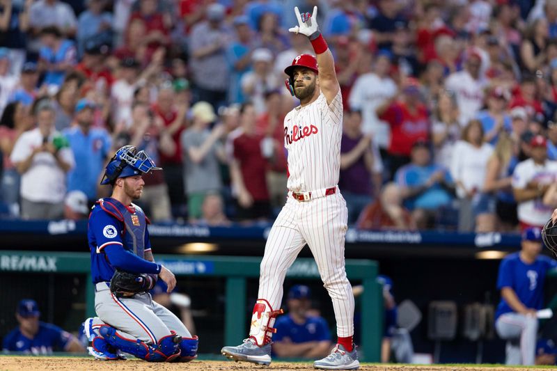 May 21, 2024; Philadelphia, Pennsylvania, USA; ]Philadelphia Phillies first base Bryce Harper (3) reacts in front of Texas Rangers catcher Jonah Heim (28) after hitting a home run during the sixth inning at Citizens Bank Park. Mandatory Credit: Bill Streicher-USA TODAY Sports