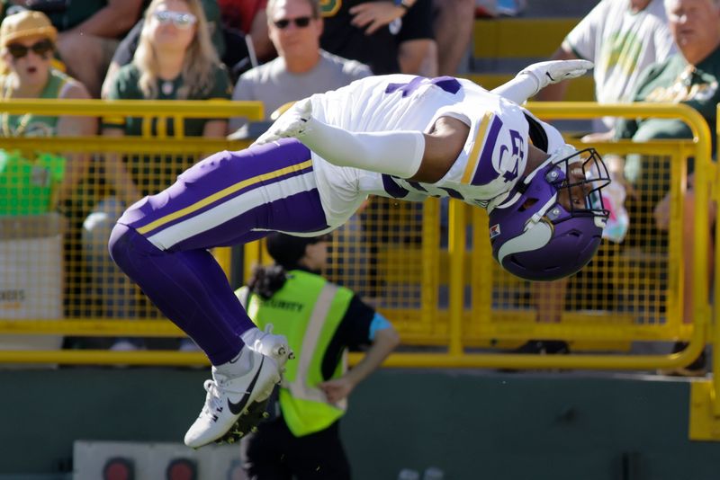 Minnesota Vikings safety Camryn Bynum does a backflip as he celebrates a fumble recovery during the second half of an NFL football game against the Green Bay Packers, Sunday, Sept. 29, 2024, in Green Bay, Wis. (AP Photo/Mike Roemer)