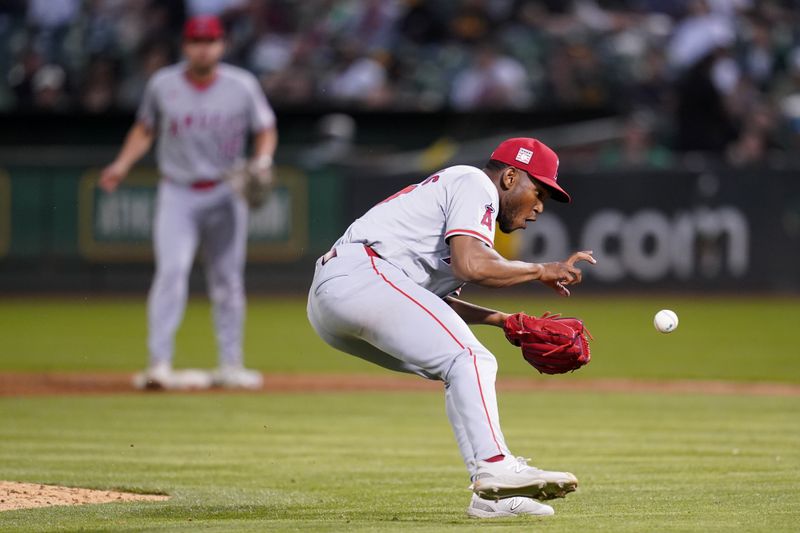 Jul 19, 2024; Oakland, California, USA; Los Angeles Angels pitcher Roansy Contreras (57) fields a ground ball before making a throw to first to record an out against the Oakland Athletics in the sixth inning at Oakland-Alameda County Coliseum. Mandatory Credit: Cary Edmondson-USA TODAY Sports