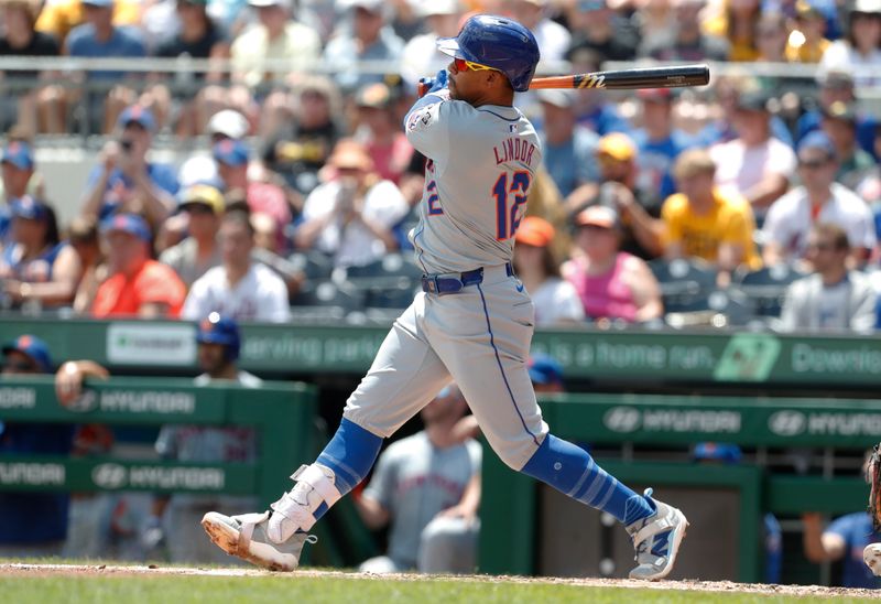 Jul 7, 2024; Pittsburgh, Pennsylvania, USA;  New York Mets shortstop Francisco Lindor (12) hits a single against the Pittsburgh Pirates during the third inning at PNC Park. Mandatory Credit: Charles LeClaire-USA TODAY Sports