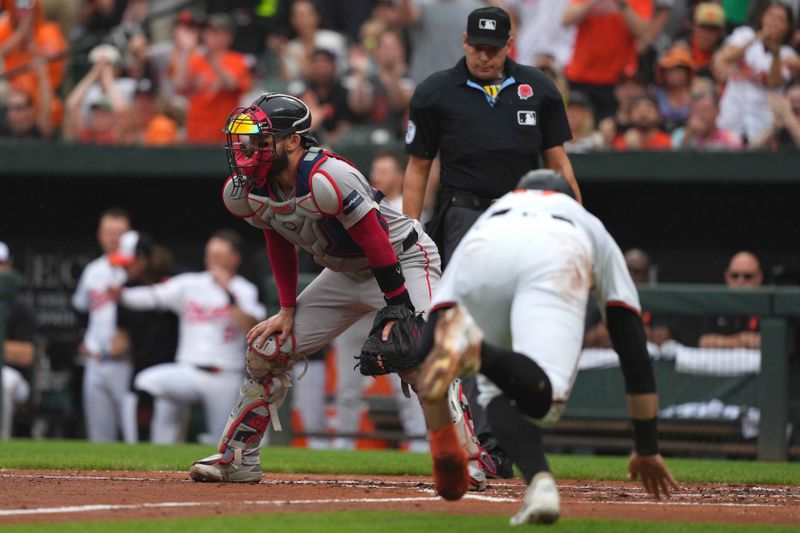 May 27, 2024; Baltimore, Maryland, USA; Baltimore Orioles outfielder Colton Cowser (17) scores in the second inning past Boston Red Sox catcher Connor Wong (12) at Oriole Park at Camden Yards. Mandatory Credit: Mitch Stringer-USA TODAY Sports