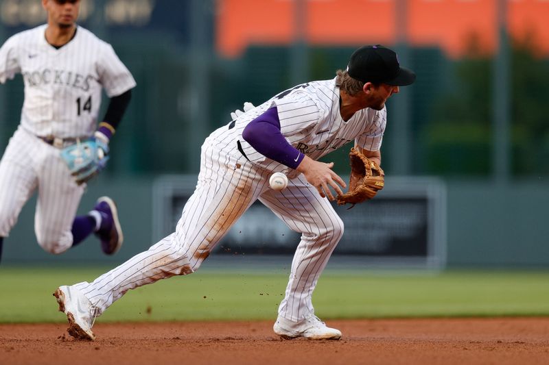 Apr 24, 2024; Denver, Colorado, USA; Colorado Rockies third baseman Ryan McMahon (24) drops the ball on a play in the second inning against the San Diego Padres at Coors Field. Mandatory Credit: Isaiah J. Downing-USA TODAY Sports