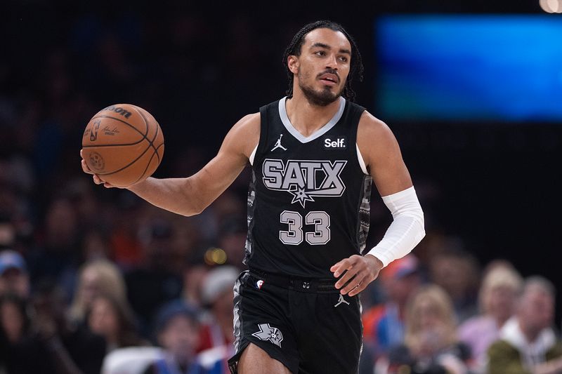 OKLAHOMA CITY, OKLAHOMA - APRIL 10: Tre Jones #33 of the San Antonio Spurs brings the ball up court during the first half against the Oklahoma City Thunder at Paycom Center on April 10, 2024 in Oklahoma City, Oklahoma. NOTE TO USER: User expressly acknowledges and agrees that, by downloading and or using this Photograph, user is consenting to the terms and conditions of the Getty Images License Agreement. (Photo by Joshua Gateley/Getty Images)