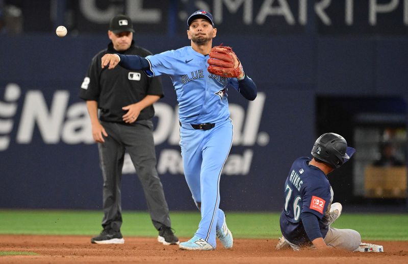 Apr 20, 2025; Toronto, Ontario, CAN;  Toronto Blue Jays second baseman Andres Gimenez (0) cannot turn a double play after forcing out Seattle Mariners second baseman Leo Rivas (76) in the sixth inning at Rogers Centre. Mandatory Credit: Dan Hamilton-Imagn Images