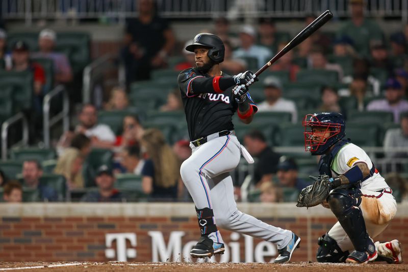 Apr 24, 2024; Atlanta, Georgia, USA; Miami Marlins left fielder Bryan De La Cruz (14) hits a single against the Atlanta Braves in the ninth inning at Truist Park. Mandatory Credit: Brett Davis-USA TODAY Sports