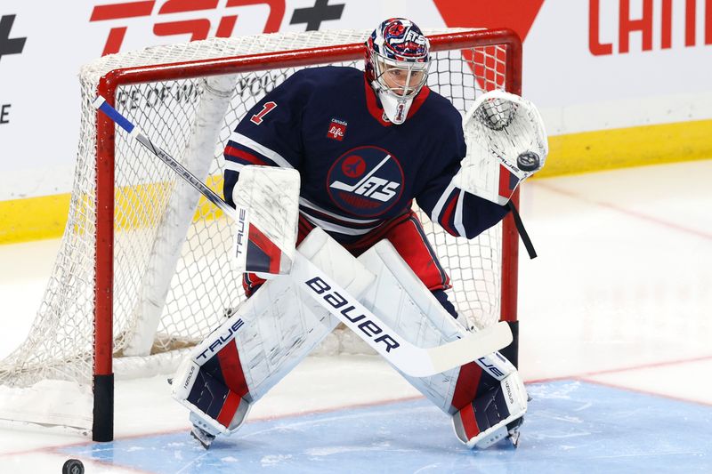 Oct 20, 2024; Winnipeg, Manitoba, CAN; Winnipeg Jets goaltender Eric Comrie (1) warms up before a game against the Pittsburgh Penguins at Canada Life Centre. Mandatory Credit: James Carey Lauder-Imagn Images