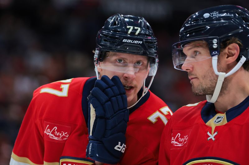 Nov 27, 2024; Sunrise, Florida, USA; Florida Panthers defenseman Niko Mikkola (77) talks to defenseman Dmitry Kulikov (7) during the second period at Amerant Bank Arena. Mandatory Credit: Sam Navarro-Imagn Images