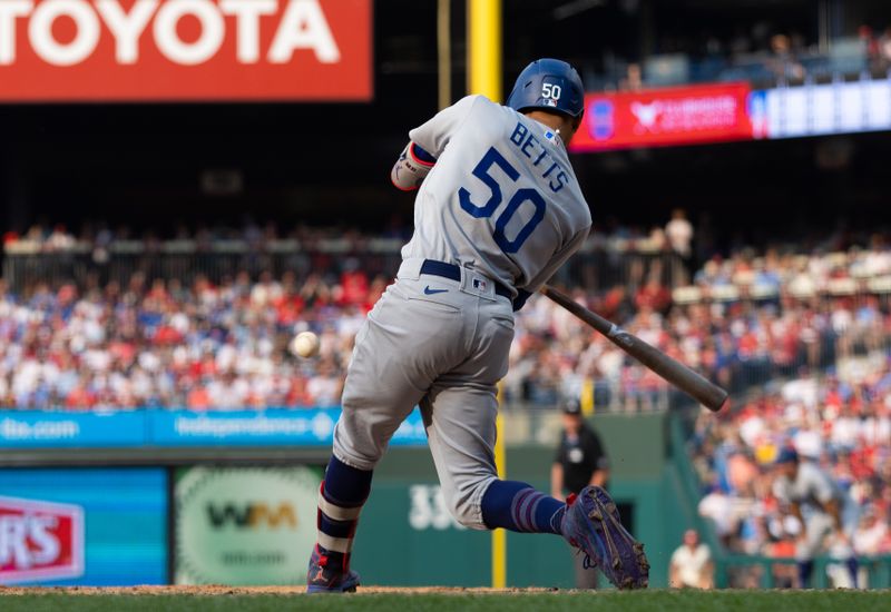 Jun 10, 2023; Philadelphia, Pennsylvania, USA; Los Angeles Dodgers right fielder Mookie Betts (50) hits an RBI single during the seventh inning against the Philadelphia Phillies at Citizens Bank Park. Mandatory Credit: Bill Streicher-USA TODAY Sports