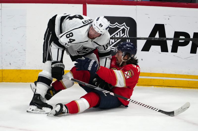 Jan 11, 2024; Sunrise, Florida, USA; Los Angeles Kings defenseman Vladislav Gavrikov (84) holds Florida Panthers left wing Ryan Lomberg (94) on the ice during the first period at Amerant Bank Arena. Mandatory Credit: Jasen Vinlove-USA TODAY Sports