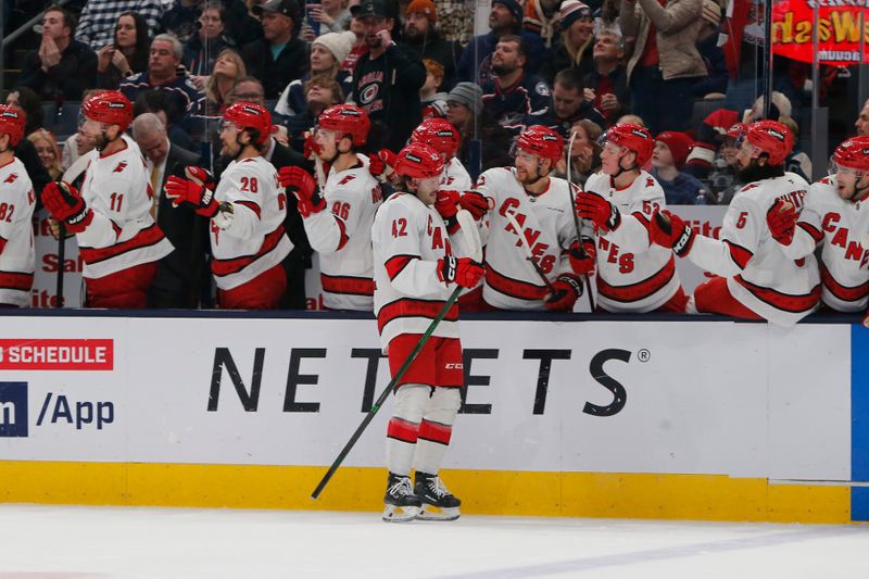 Dec 31, 2024; Columbus, Ohio, USA; Carolina Hurricanes defenseman Ty Smith (42) celebrates his goal against the Columbus Blue Jackets during the first period at Nationwide Arena. Mandatory Credit: Russell LaBounty-Imagn Images