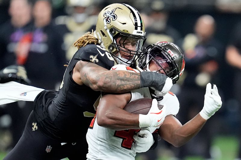 Tampa Bay Buccaneers running back Sean Tucker, right, runs against New Orleans Saints defensive end Chase Young during the second half of an NFL football game in New Orleans, Sunday, Oct. 13, 2024. (AP Photo/Michael Conroy)