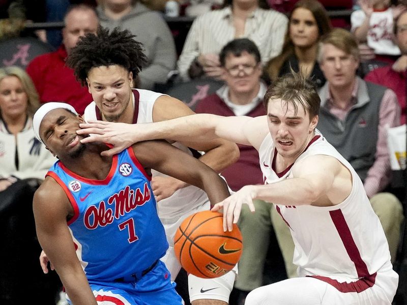 Jan 14, 2025; Tuscaloosa, AL, USA; Ole Miss guard Davon Barnes (7) gets a hand in the face as Alabama forward Grant Nelson (4) grabs a loose ball at Coleman Coliseum. Ole Miss defeated Alabama 74-64. Mandatory Credit: Gary Cosby Jr./USA TODAY Network via Imagn Images
