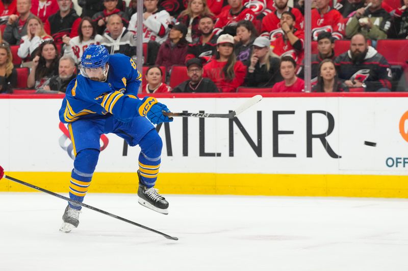 Nov 8, 2025; Raleigh, North Carolina, USA;  Buffalo Sabres right wing Alex Tuch (89) gets the shot away against Carolina Hurricanes during the second period at Lenovo Center. Mandatory Credit: James Guillory-Imagn Images